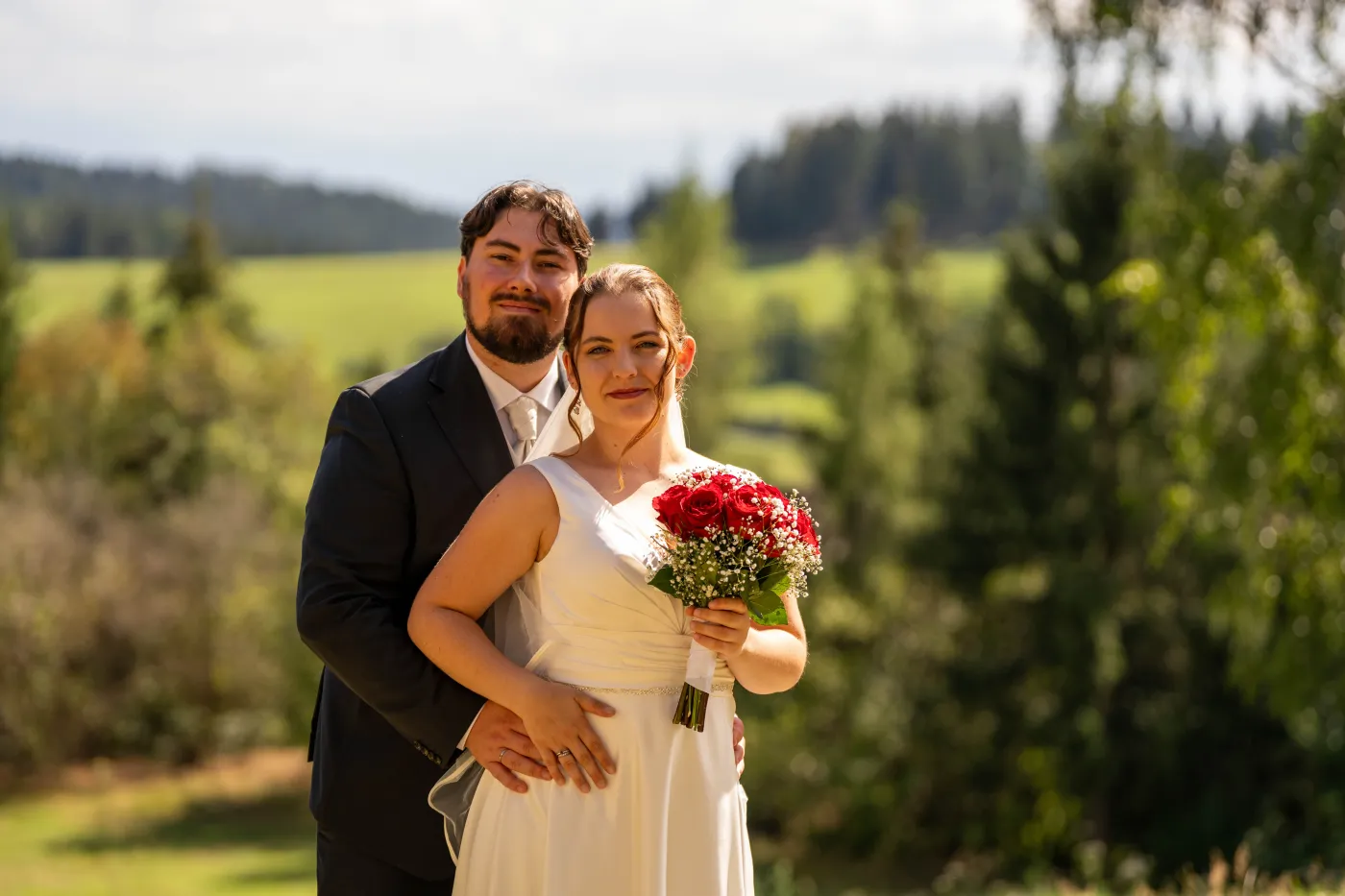 Brautpaar vor Wiese und Wald