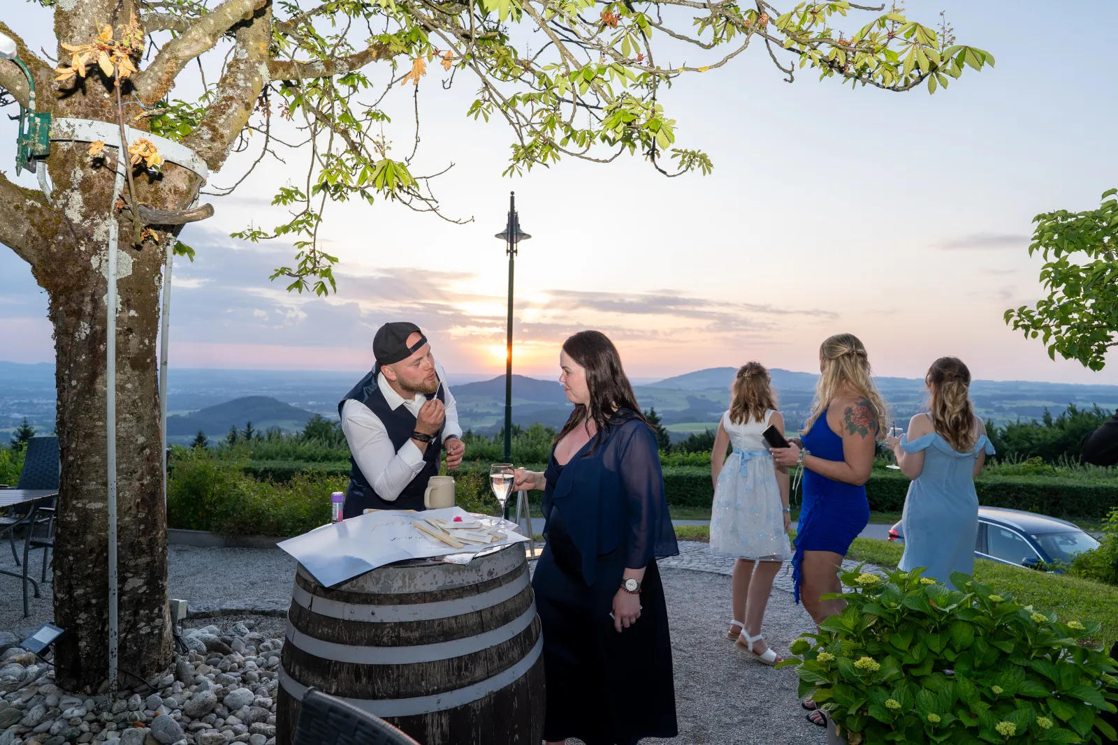 Hochzeitsgesellschaft auf der Terrasse bei Sonnenuntergang